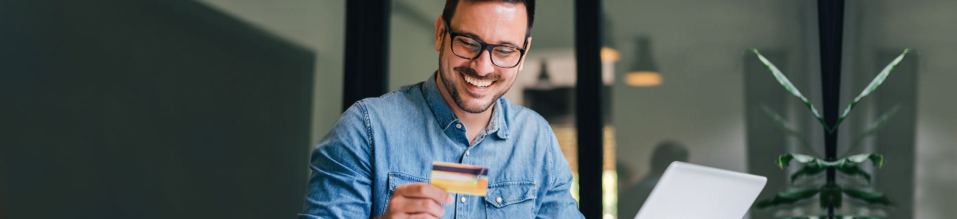 Man shopping online with credit card in hand