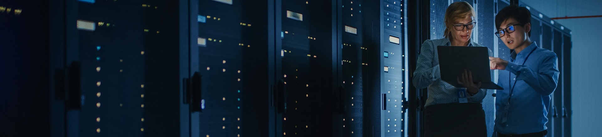 Woman and man looking at a laptop in a server room