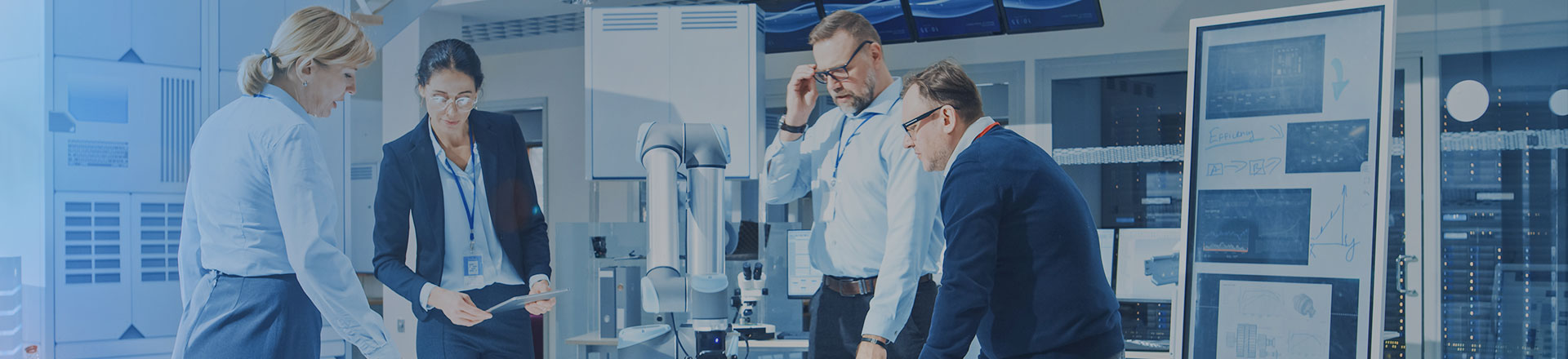 People meeting and looking at stats in a lab with data centre in background