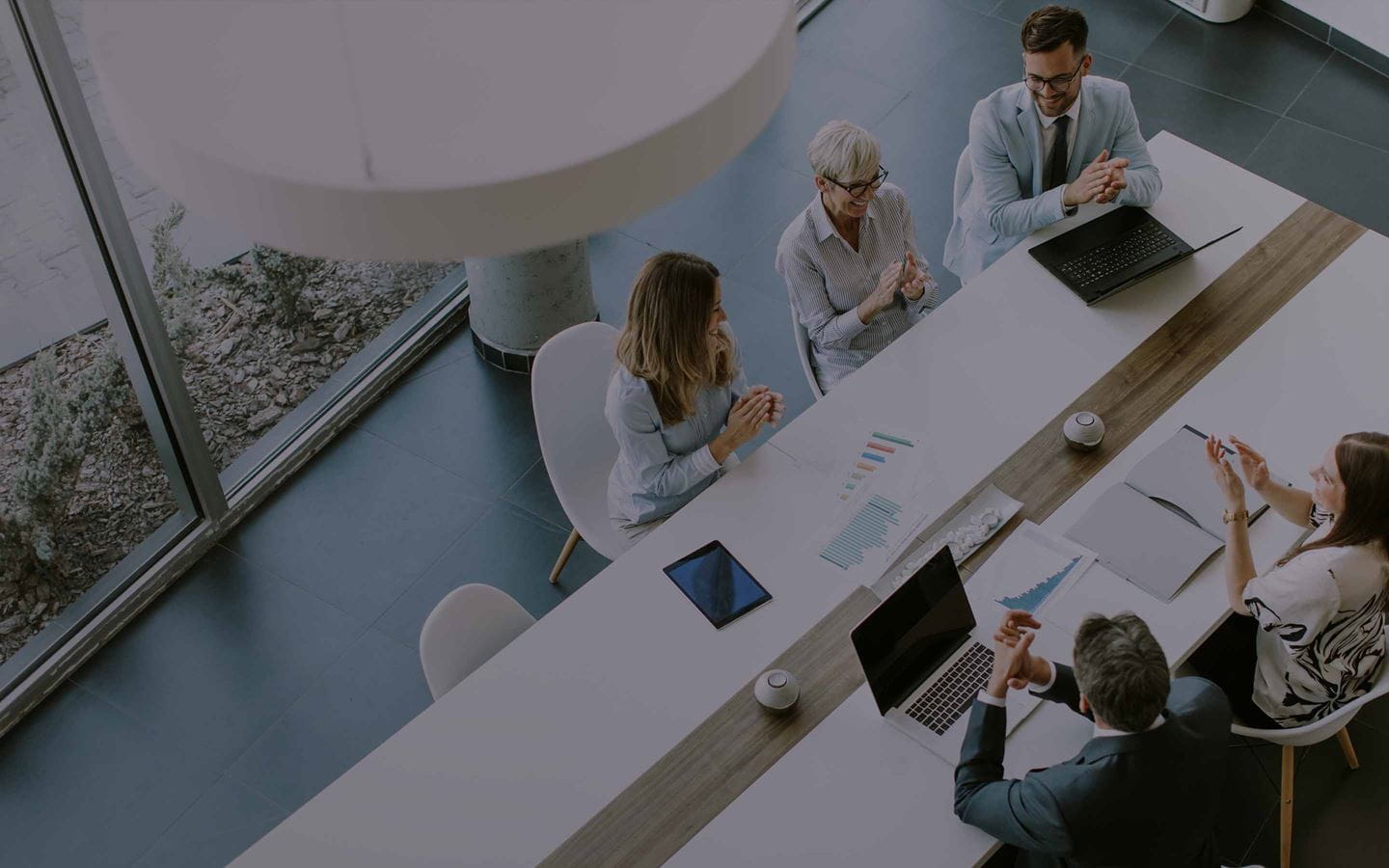 A team in a meeting room with laptops and tablets
