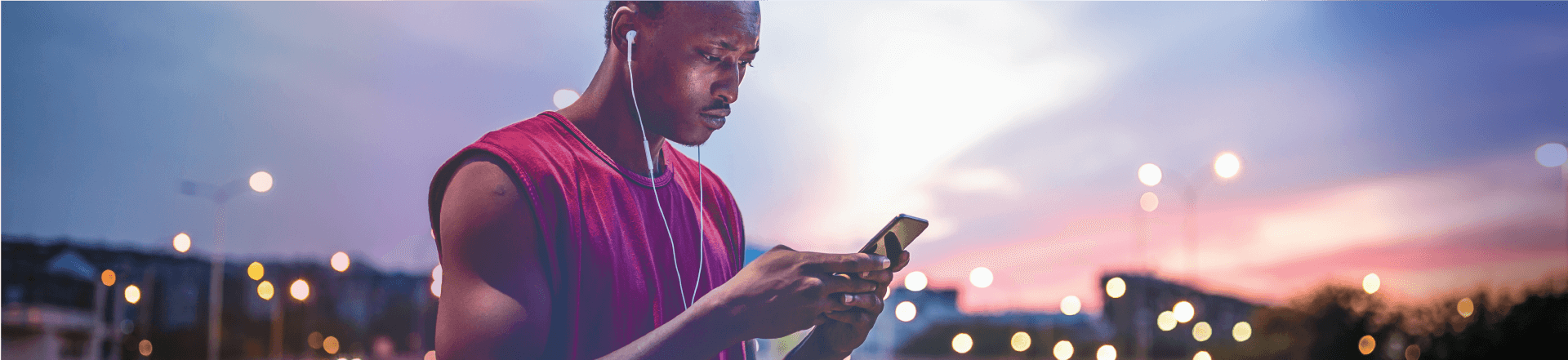Sports man with headphones looking at his mobile phone