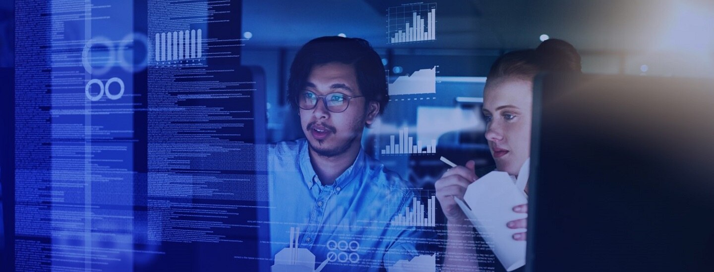 Two people looking at the the big computer monitor