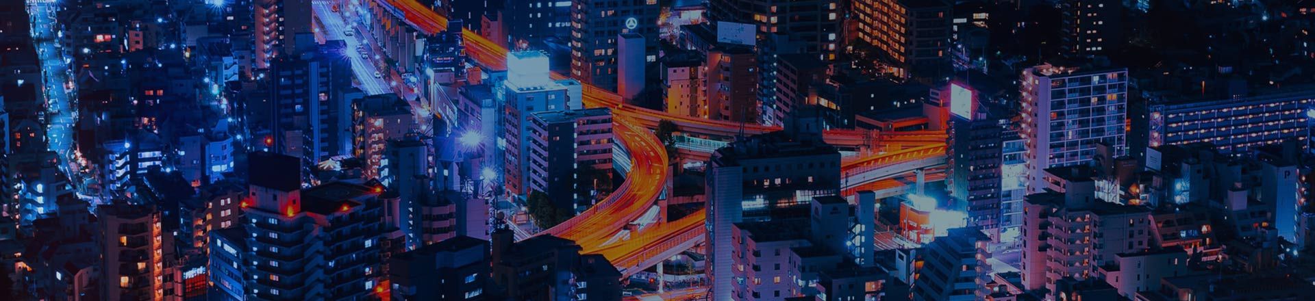 Arial view of city at night with light trails on road