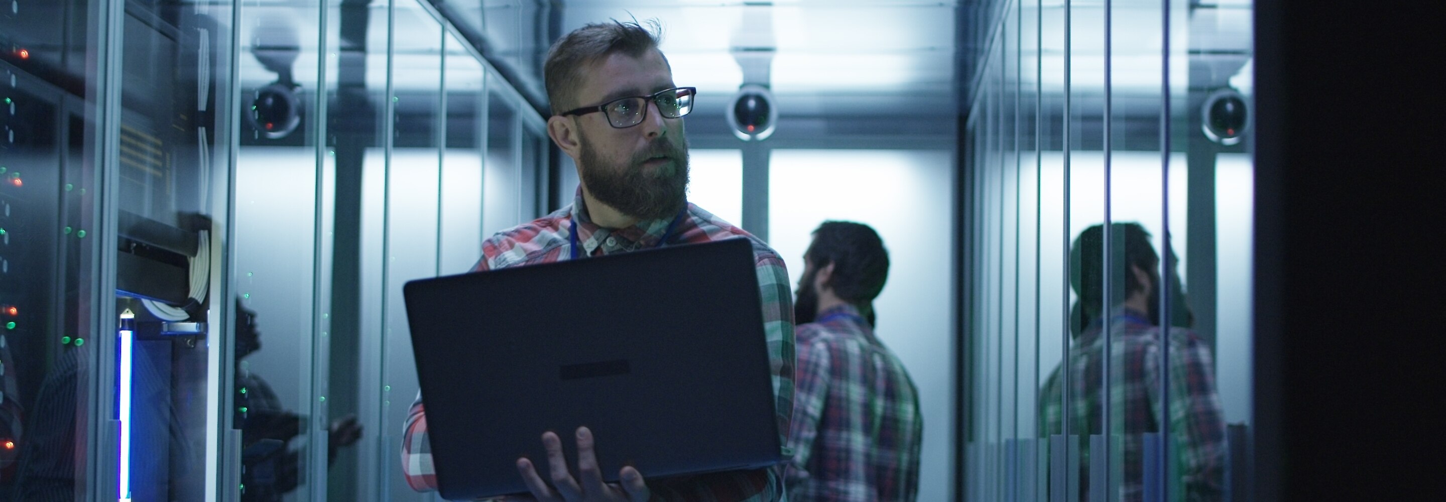 Man with laptop in a server room