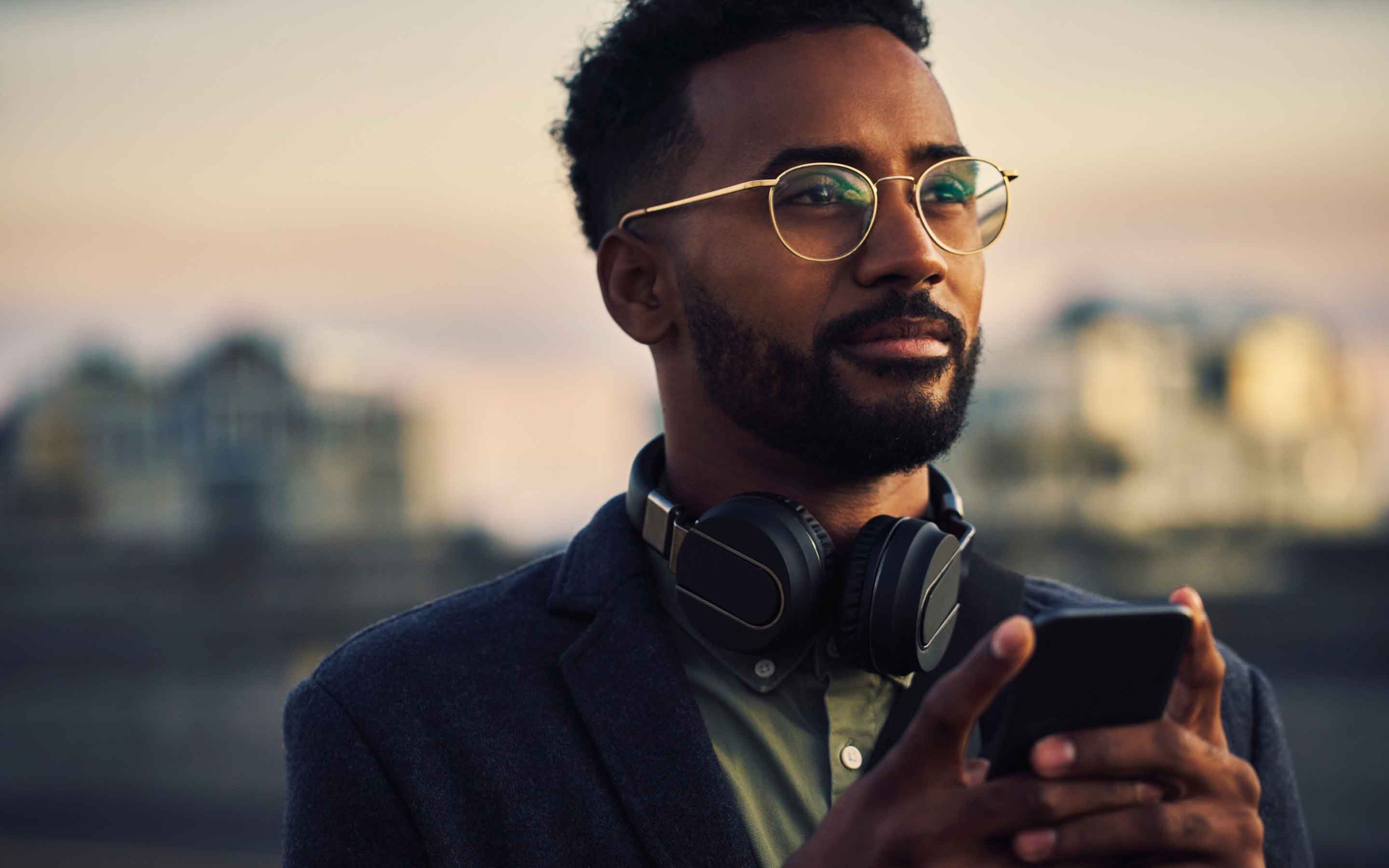 Man holding his phone and looking into the distance