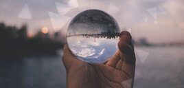 A hand holding a glass globe